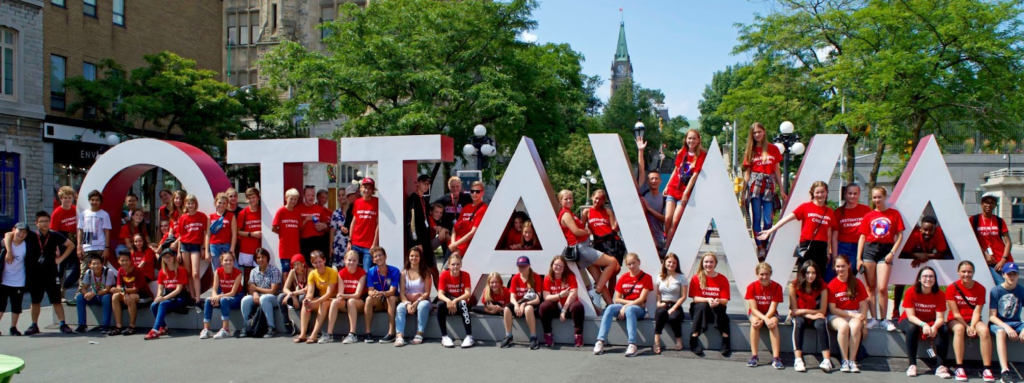 Groupes de jeunes en camp linguistique devant le signe d’Ottawa.