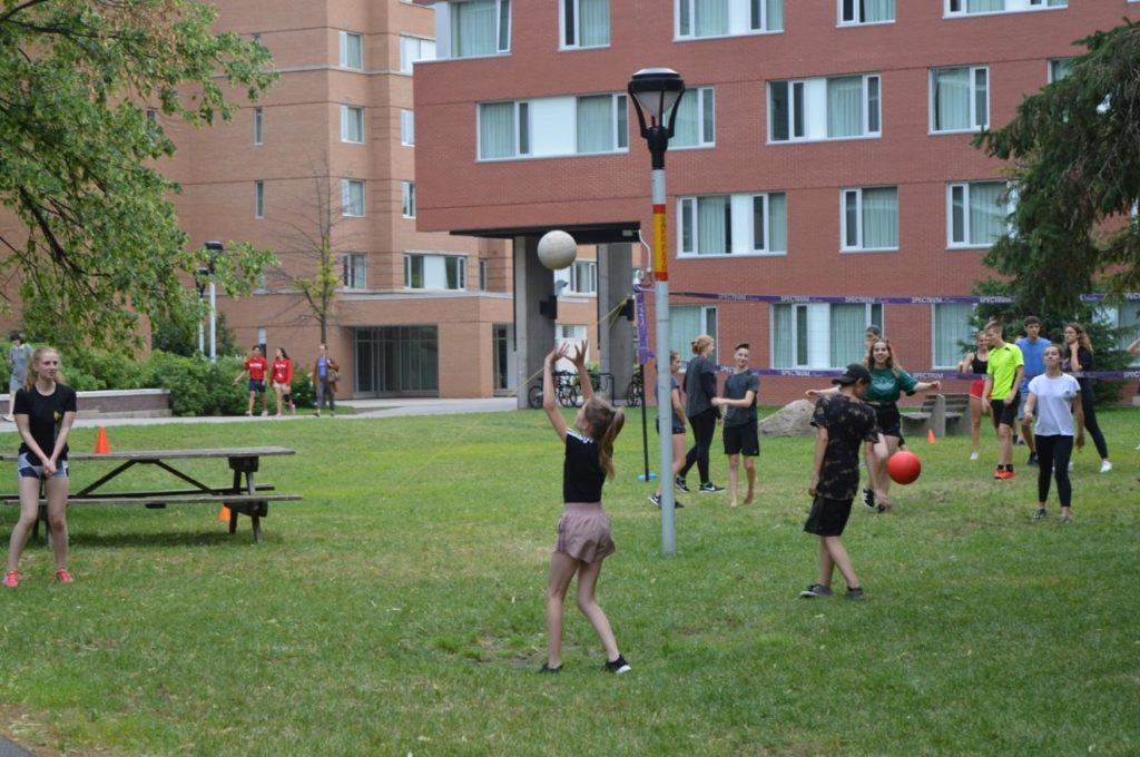 Ados en camp linguistique à Ottawa jouant au ballon sur le campus universitaire.