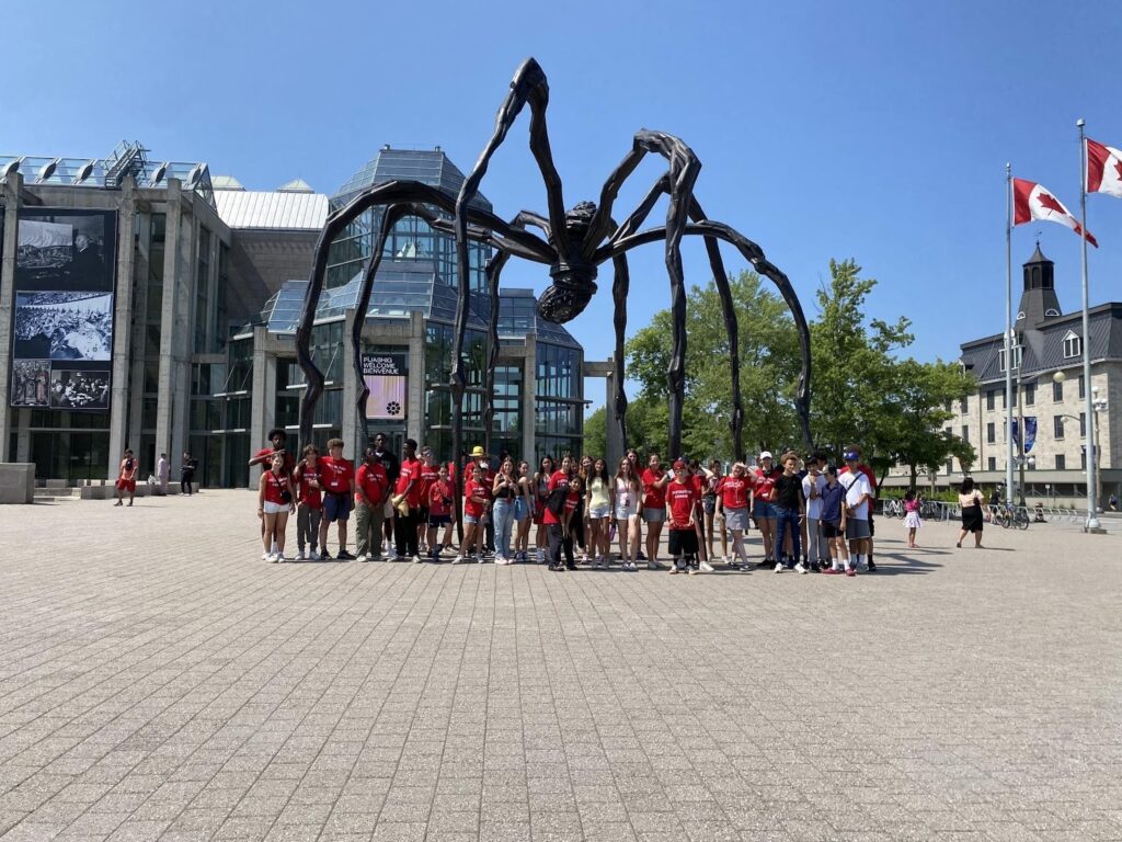 Groupe d’adolescents en excursion culturelle à Ottawa pendant une colonie de vacances en anglais, favorisant l’immersion linguistique.